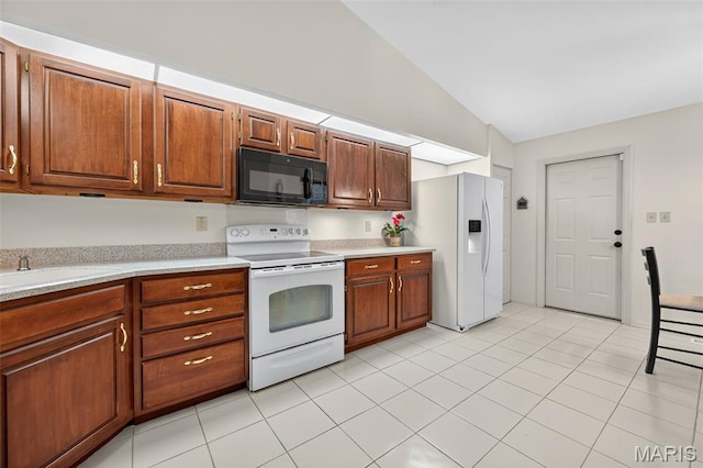 425 Charter Way Dr, Wildwood, MO 63040 - kitchen with white appliances, vaulted ceiling, light countertops, light tile patterned floors, and brown cabinets