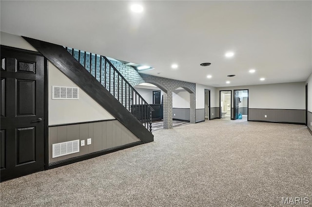 20 Hiddenbrook Dr, Black Jack, MO 63033 - unfurnished living room featuring arched walkways, carpet, stairway, a wainscoted wall, and recessed lighting