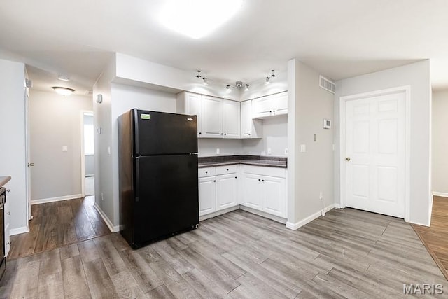 2313 College, Belleville, IL 62221 - kitchen with freestanding refrigerator, light wood-style floors, dark countertops, and white cabinets