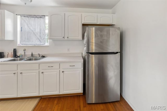 922 Benjamin Dr, Ofallon, IL 62269 - kitchen with freestanding refrigerator, white cabinetry, and wood finished floors