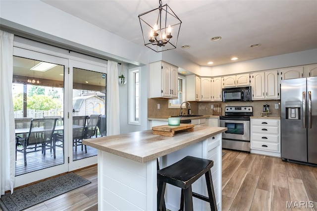 101 Archview Dr, Shiloh, IL 62221 - kitchen with stainless steel appliances, light wood finished floors, a chandelier, white cabinets, and recessed lighting