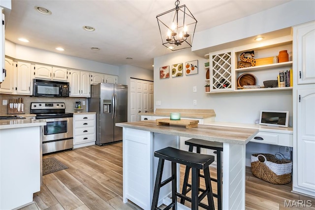 101 Archview Dr, Shiloh, IL 62221 - kitchen with stainless steel appliances, a kitchen breakfast bar, light wood-style flooring, light countertops, and recessed lighting