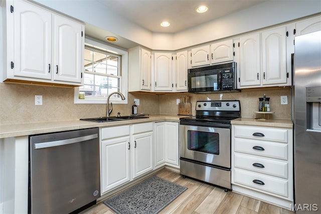 101 Archview Dr, Shiloh, IL 62221 - kitchen with appliances with stainless steel finishes, light countertops, white cabinets, light wood finished floors, and decorative backsplash