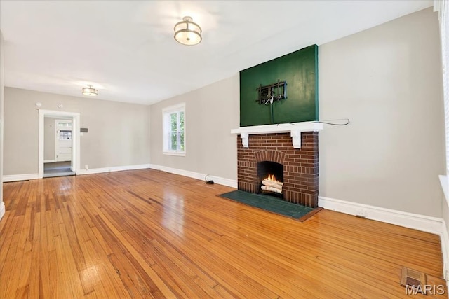 2057-2059 Ann Ave, Saint Louis, MO 63104 - unfurnished living room featuring hardwood / wood-style flooring and a brick fireplace