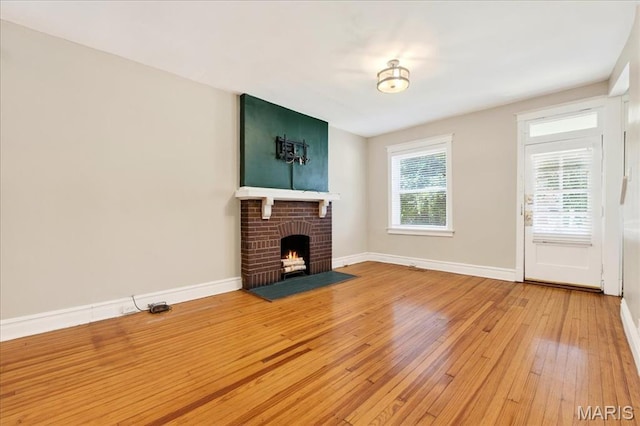2057-2059 Ann Ave, Saint Louis, MO 63104 - unfurnished living room featuring hardwood / wood-style flooring and a brick fireplace