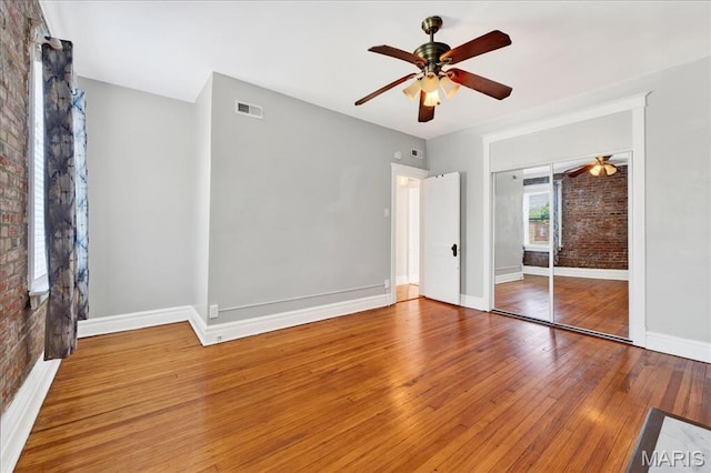 2057-2059 Ann Ave, Saint Louis, MO 63104 - unfurnished bedroom featuring brick wall, wood-type flooring, ceiling fan, and a closet