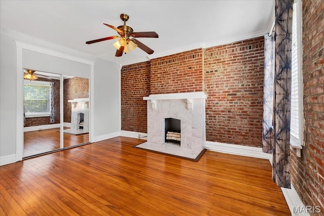 2057-2059 Ann Ave, Saint Louis, MO 63104 - unfurnished living room with a fireplace, brick wall, a ceiling fan, hardwood / wood-style flooring, and ornamental molding