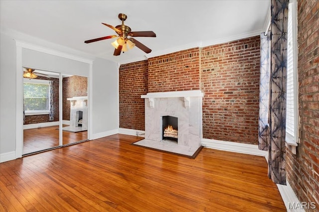 2057-2059 Ann Ave, Saint Louis, MO 63104 - unfurnished living room featuring a high end fireplace, brick wall, ceiling fan, hardwood / wood-style floors, and ornamental molding