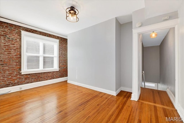 2057-2059 Ann Ave, Saint Louis, MO 63104 - unfurnished room with light wood-type flooring, brick wall, and a smoke detector