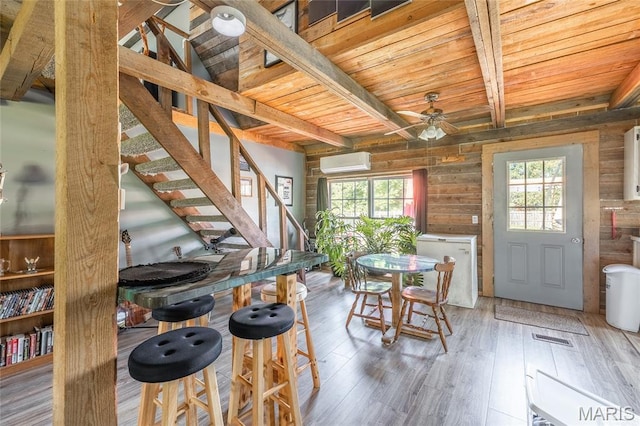 19612 State Route M, Edgar Springs, MO 65462 - dining space featuring a wall mounted AC, ceiling fan, a wooden ceiling with exposed beams, wood finished floors, and stairs