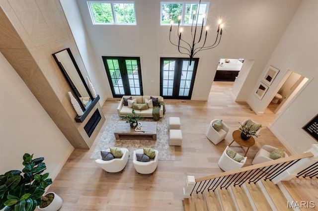 224 Oak Tree Dr, Webster Groves, MO 63119 - living area featuring french doors, a towering ceiling, and wood finished floors