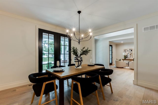 224 Oak Tree Dr, Webster Groves, MO 63119 - dining space featuring french doors, light wood-style flooring, ornamental molding, and a chandelier