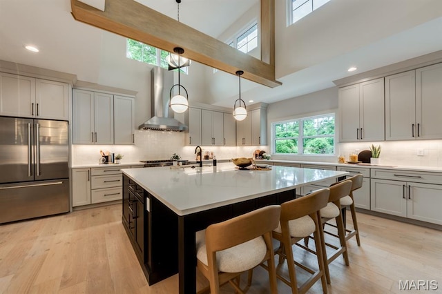 224 Oak Tree Dr, Webster Groves, MO 63119 - kitchen featuring high end fridge, wall chimney exhaust hood, a high ceiling, decorative backsplash, and recessed lighting