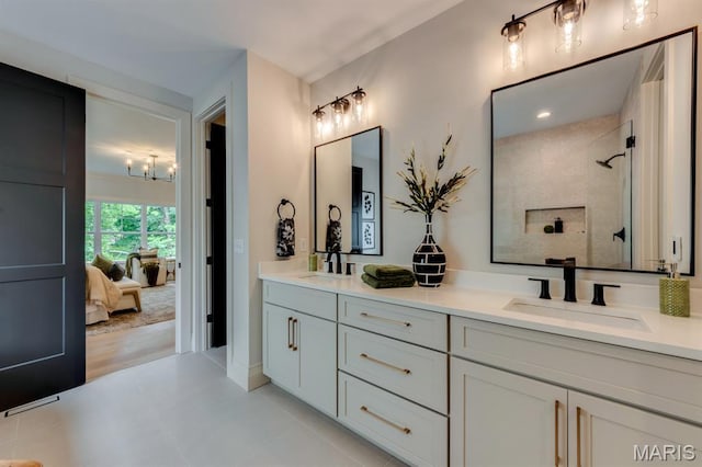 224 Oak Tree Dr, Webster Groves, MO 63119 - ensuite bathroom featuring double vanity, a chandelier, and tiled shower