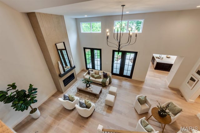 224 Oak Tree Dr, Webster Groves, MO 63119 - living area featuring a chandelier, light wood-style flooring, recessed lighting, a towering ceiling, and a tile fireplace