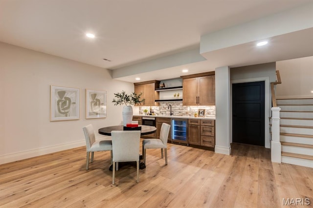 224 Oak Tree Dr, Webster Groves, MO 63119 - dining room with wet bar, wine cooler, light wood finished floors, stairway, and recessed lighting