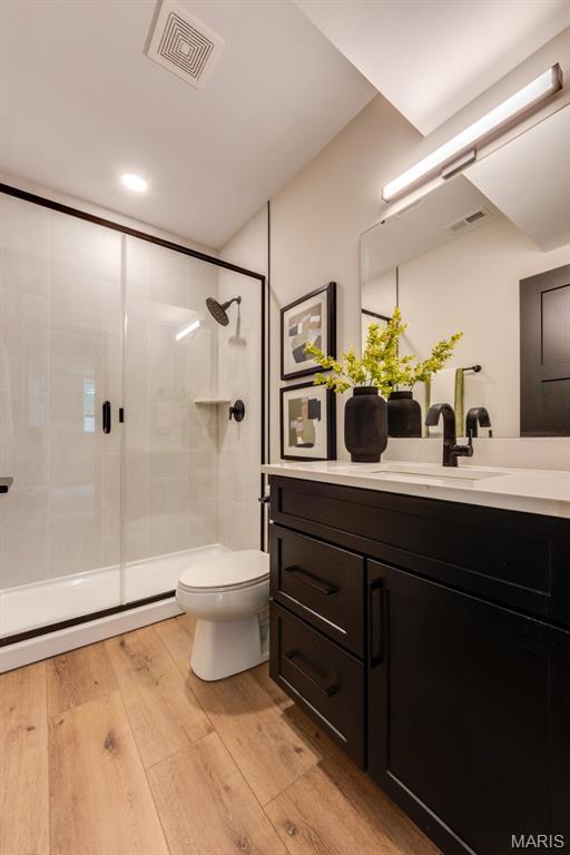 224 Oak Tree Dr, Webster Groves, MO 63119 - bathroom featuring vanity, a shower stall, wood finished floors, and recessed lighting
