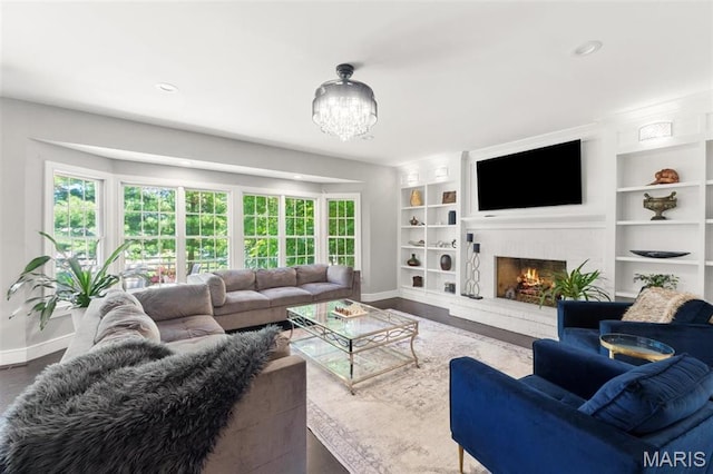 12429 Nicholas Ln, Saint Louis, MO 63131 - living room with built in shelves, a chandelier, a fireplace, and recessed lighting