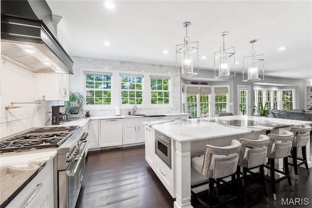 12429 Nicholas Ln, Saint Louis, MO 63131 - kitchen featuring premium range hood, appliances with stainless steel finishes, recessed lighting, plenty of natural light, and a kitchen island