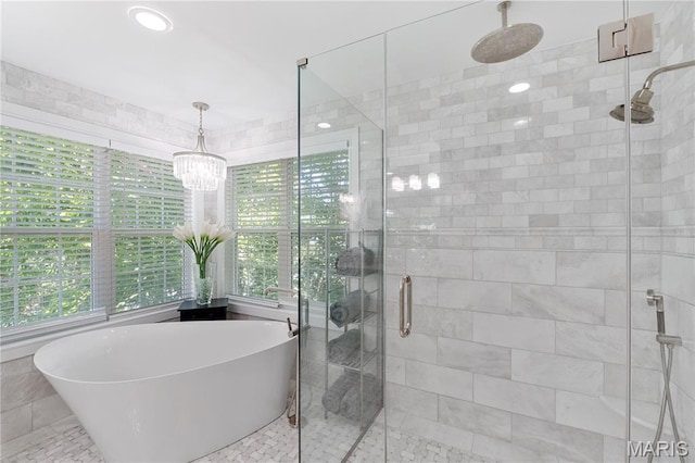 12429 Nicholas Ln, Saint Louis, MO 63131 - bathroom with healthy amount of natural light, a shower stall, a soaking tub, and a chandelier
