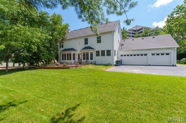 12429 Nicholas Ln, Saint Louis, MO 63131 - rear view of house with driveway, a yard, and an attached garage