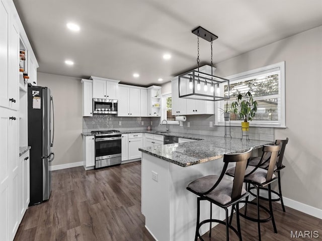 1201 Cheverly Ct, Saint Louis, MO 63146 - kitchen with appliances with stainless steel finishes, open shelves, a peninsula, light stone countertops, and white cabinetry
