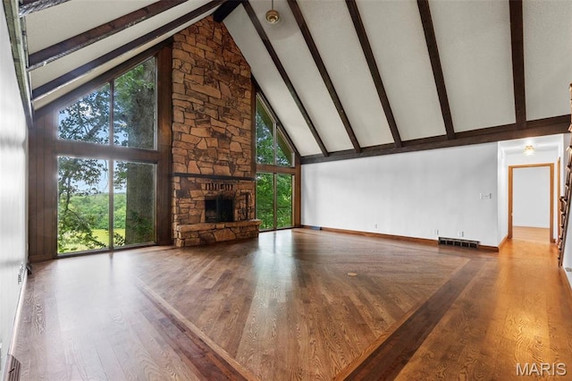 1938 State Highway Oo, Whitewater, MO 63785 - unfurnished living room with high vaulted ceiling, beamed ceiling, a stone fireplace, healthy amount of natural light, and wood finished floors