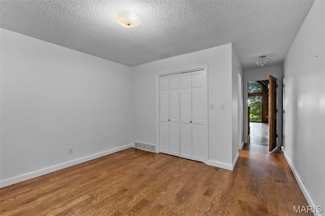 1938 State Highway Oo, Whitewater, MO 63785 - unfurnished bedroom featuring wood finished floors, a textured ceiling, and a closet