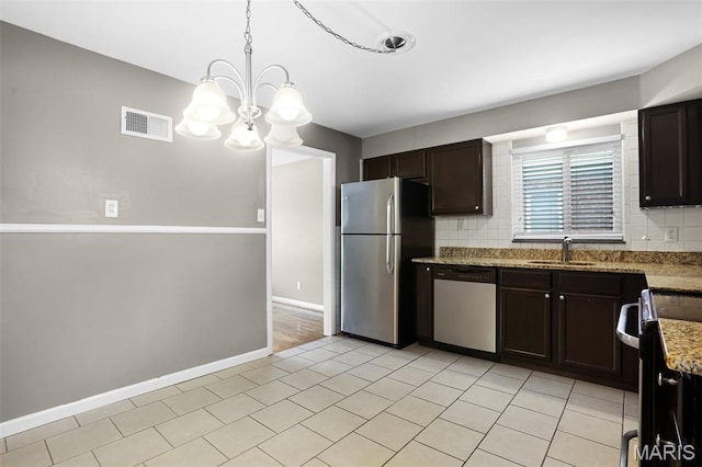 11380 Manchester Rd, Kirkwood, MO 63122 - kitchen featuring appliances with stainless steel finishes, tasteful backsplash, dark brown cabinets, and a chandelier