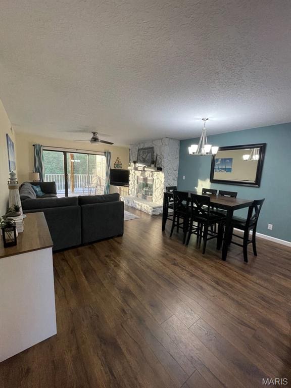 611 Lazy Days Rd Unit Z-1, Osage Beach, MO 65065 - dining area featuring a textured ceiling, dark wood finished floors, a chandelier, a stone fireplace, and a ceiling fan