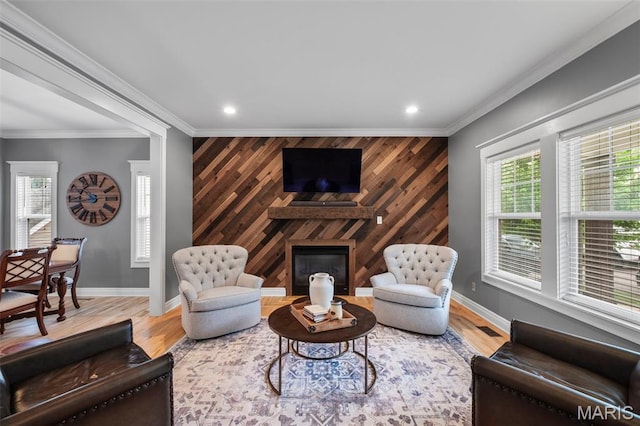 17108 Windsor Crest Blvd, Wildwood, MO 63038 - living area featuring an accent wall, plenty of natural light, a glass covered fireplace, ornamental molding, and wooden walls