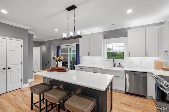 17108 Windsor Crest Blvd, Wildwood, MO 63038 - kitchen with crown molding, a breakfast bar, tasteful backsplash, light countertops, and stainless steel appliances