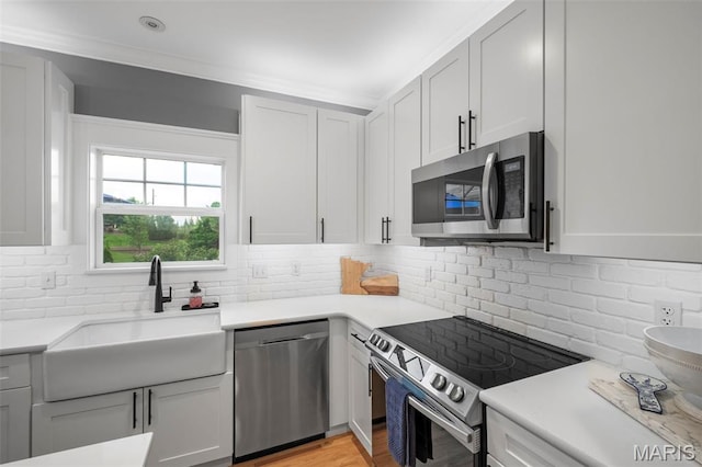 17108 Windsor Crest Blvd, Wildwood, MO 63038 - kitchen with appliances with stainless steel finishes, backsplash, light countertops, light wood-style flooring, and white cabinets