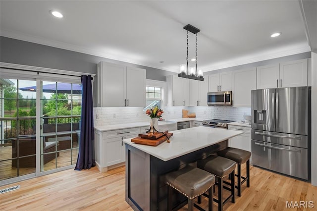17108 Windsor Crest Blvd, Wildwood, MO 63038 - kitchen with appliances with stainless steel finishes, crown molding, light countertops, decorative backsplash, and a breakfast bar area