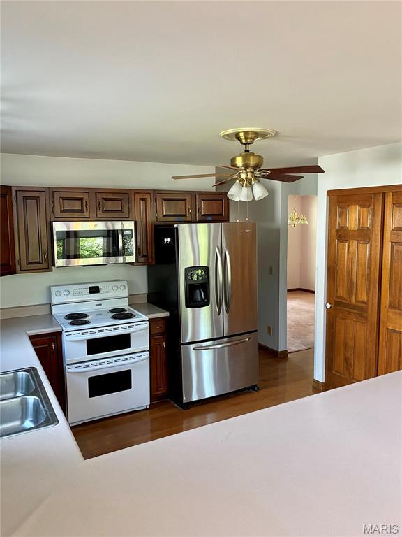 12020 Jacobson Ct, Saint Louis, MO 63044 - kitchen with stainless steel appliances, a ceiling fan, light countertops, and dark wood-style flooring