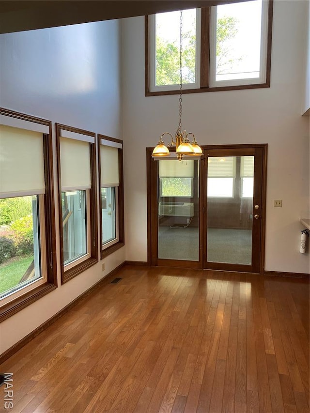 12020 Jacobson Ct, Saint Louis, MO 63044 - unfurnished room with a chandelier, wood-type flooring, a towering ceiling, and plenty of natural light