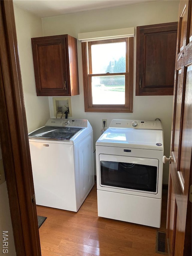12020 Jacobson Ct, Saint Louis, MO 63044 - laundry room with independent washer and dryer, cabinet space, plenty of natural light, and light wood-style flooring