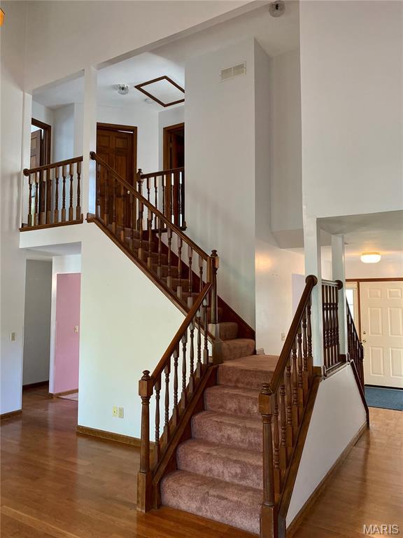 12020 Jacobson Ct, Saint Louis, MO 63044 - stairway featuring wood finished floors and a high ceiling