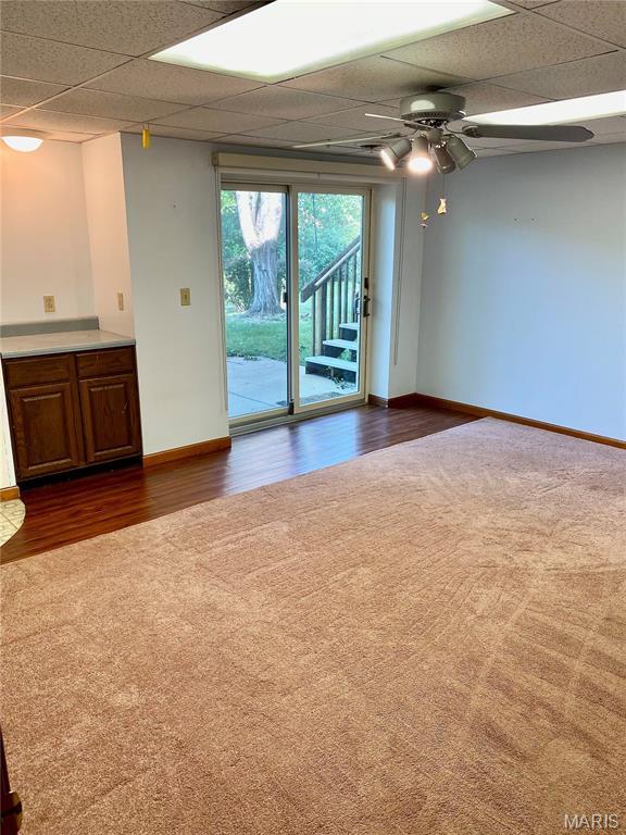 12020 Jacobson Ct, Saint Louis, MO 63044 - unfurnished room featuring a drop ceiling, dark carpet, dark wood finished floors, and a ceiling fan