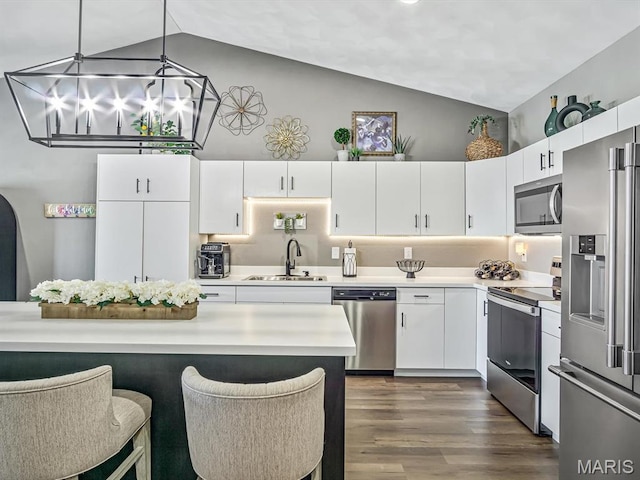 714 Applewood Creek Dr, Fairview Heights, IL 62208 - kitchen featuring stainless steel appliances, light countertops, white cabinetry, dark wood finished floors, and a breakfast bar area
