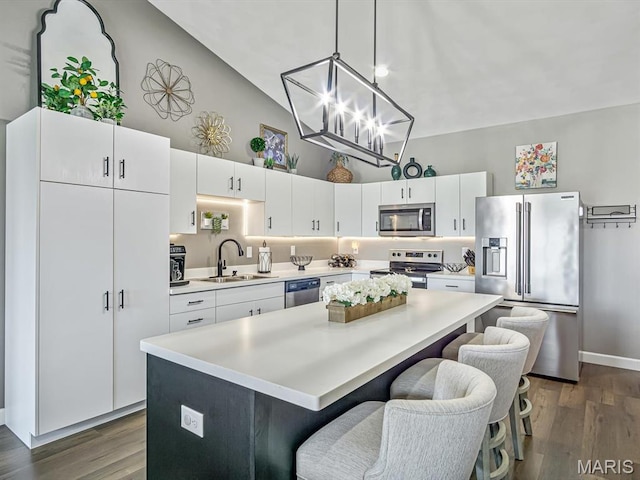 714 Applewood Creek Dr, Fairview Heights, IL 62208 - kitchen featuring appliances with stainless steel finishes, high vaulted ceiling, a kitchen island, light countertops, and white cabinetry
