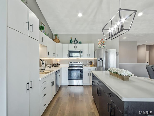 714 Applewood Creek Dr, Fairview Heights, IL 62208 - kitchen featuring appliances with stainless steel finishes, light countertops, wood finished floors, white cabinets, and recessed lighting