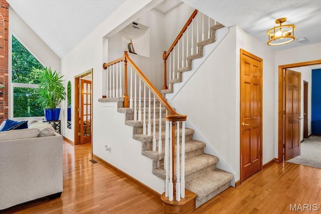 218 W Stonybrook Dr, Ofallon, IL 62269 - stairs with wood finished floors, a chandelier, and vaulted ceiling