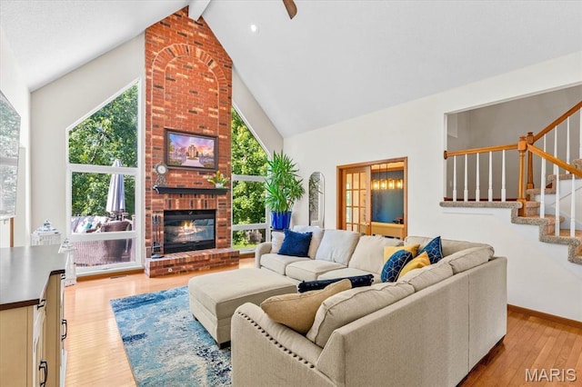 218 W Stonybrook Dr, Ofallon, IL 62269 - living room featuring high vaulted ceiling, light wood-style flooring, beam ceiling, stairway, and a fireplace