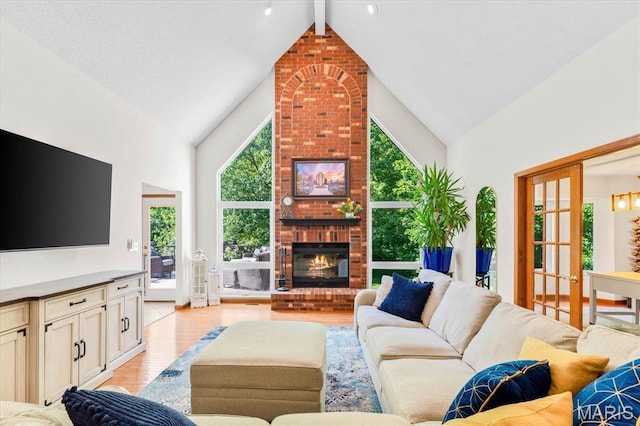 218 W Stonybrook Dr, Ofallon, IL 62269 - living area with light wood finished floors, high vaulted ceiling, a brick fireplace, and beam ceiling
