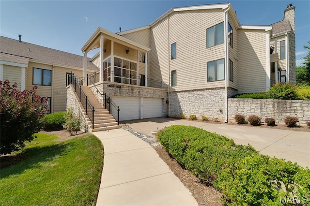 1632 Lake Knoll Dr Unit 1P, Lake St Louis, MO 63367 - view of front of house featuring concrete driveway, an attached garage, stairway, and stone siding