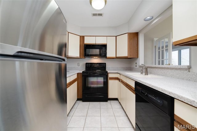 1632 Lake Knoll Dr Unit 1P, Lake St Louis, MO 63367 - kitchen with black appliances, light countertops, light tile patterned floors, and white cabinets