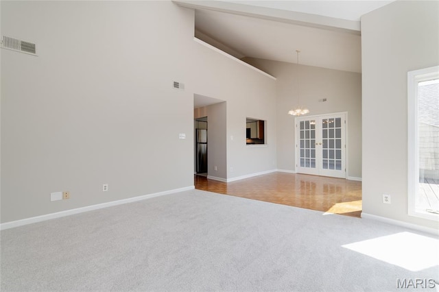 1632 Lake Knoll Dr Unit 1P, Lake St Louis, MO 63367 - carpeted empty room featuring a chandelier, high vaulted ceiling, and french doors