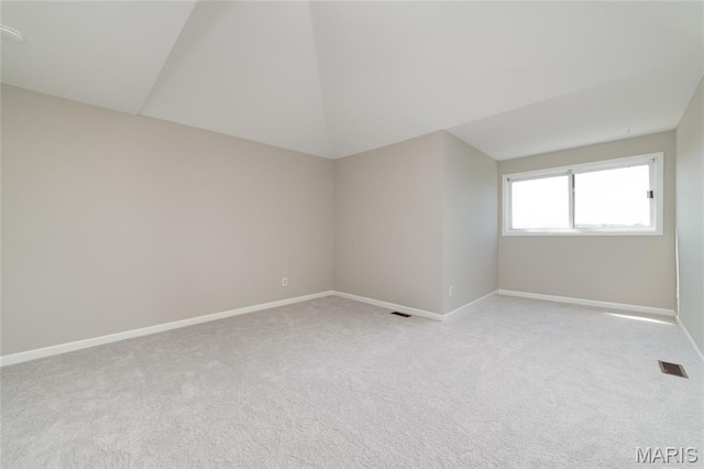 1632 Lake Knoll Dr Unit 1P, Lake St Louis, MO 63367 - spare room featuring light carpet and lofted ceiling