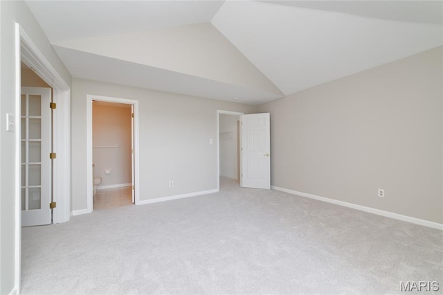 1632 Lake Knoll Dr Unit 1P, Lake St Louis, MO 63367 - unfurnished bedroom with vaulted ceiling, light carpet, a walk in closet, connected bathroom, and a closet